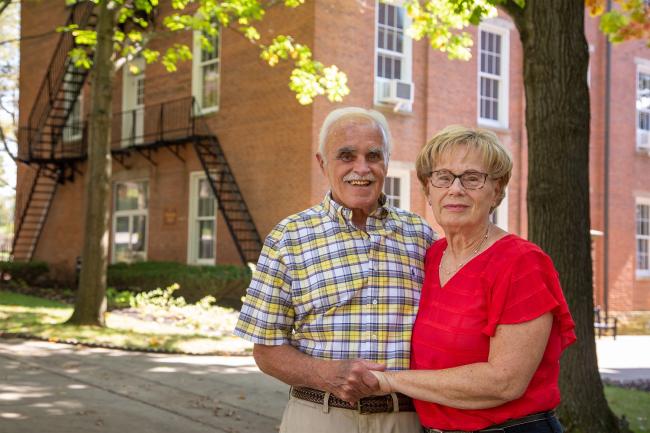 Albie and Donna Rinehart posting in front of Waynesburg University's Hanna Hall