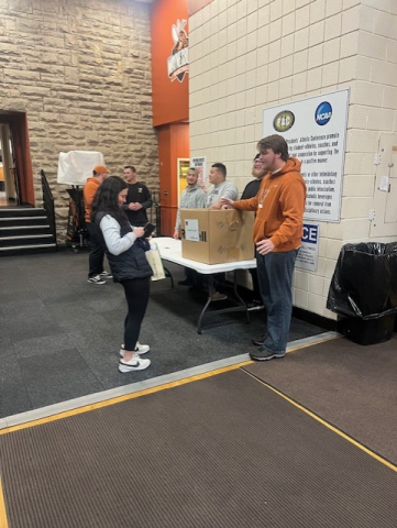 Football players who participated in the Corner Cupboard food bank drive accepting donations at Rudy Marisa Fieldhouse
