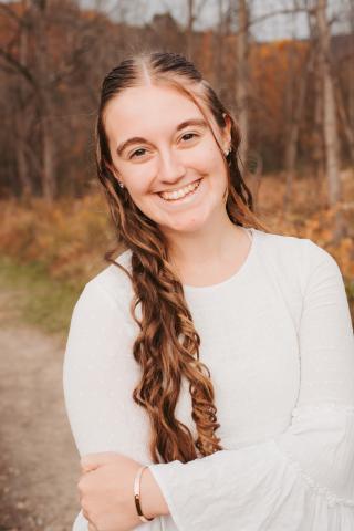 Cami Myers headshot; she is wearing a white long-sleeved shirt and smiling at the camera