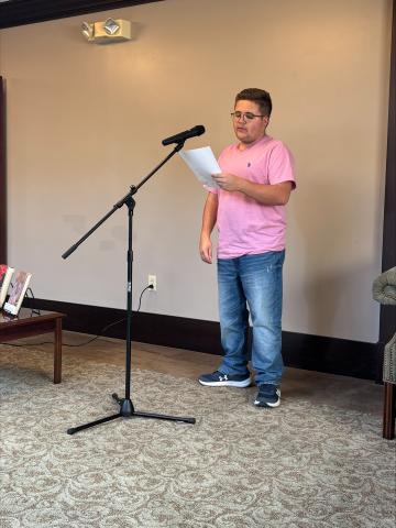A student participating in the Banned Books Week Celebration through a reading in Eberly Library's Skylight Room