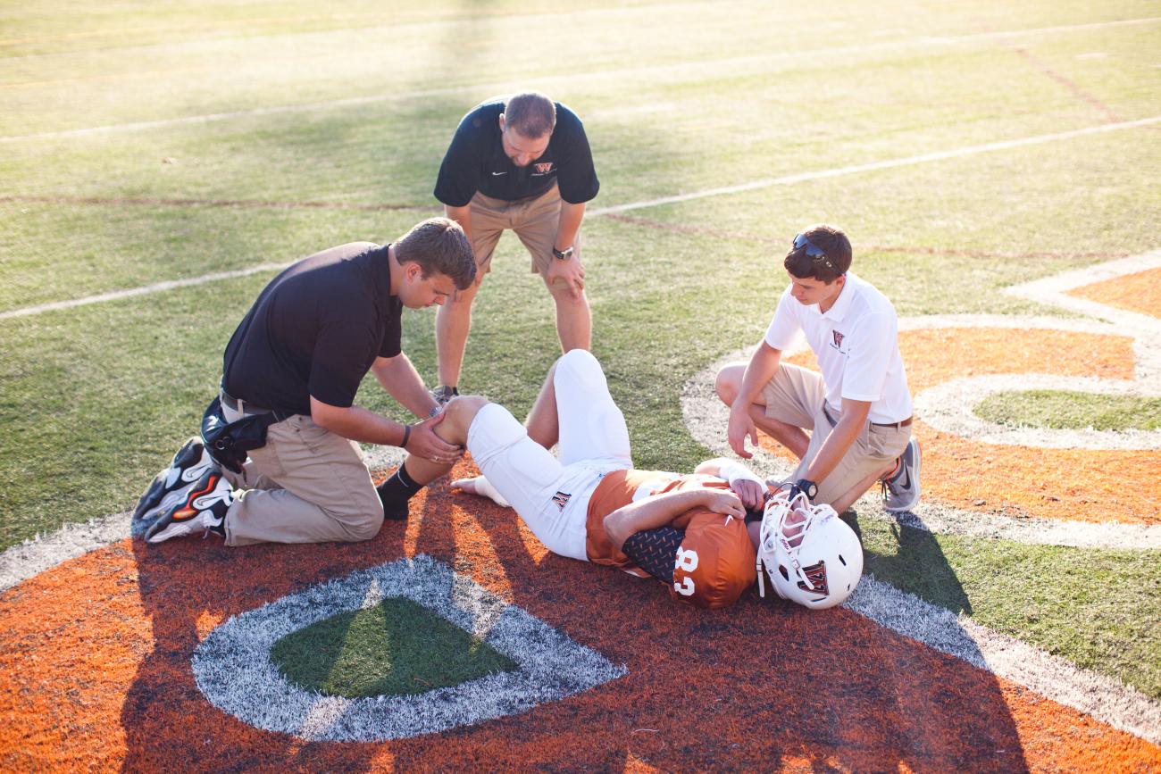 Athletic trainers with a football player