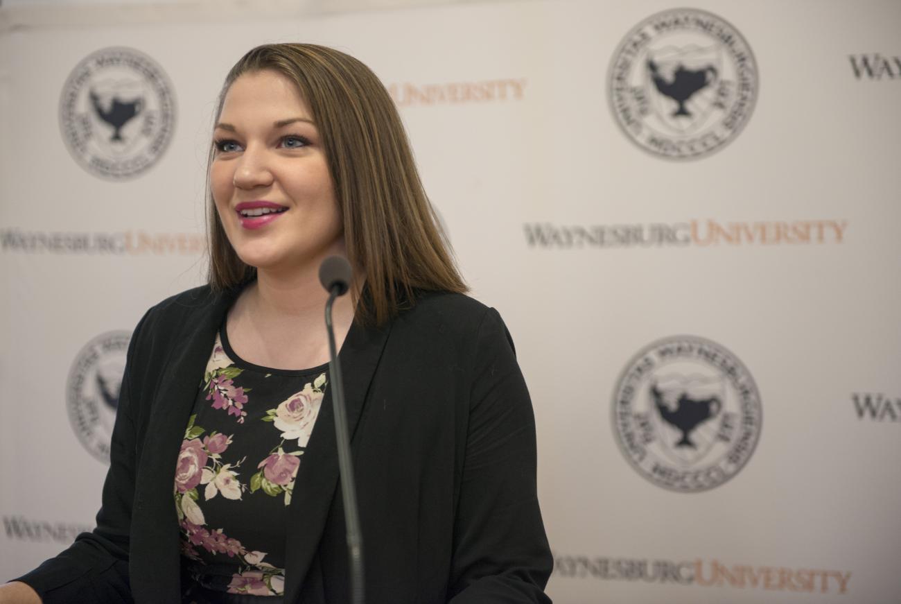 Public Relations student, Maura, announces WU's President at a press conference