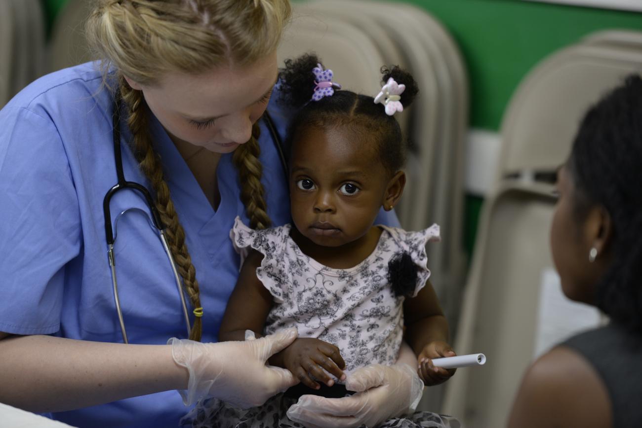 student hearing the heart of a little girl