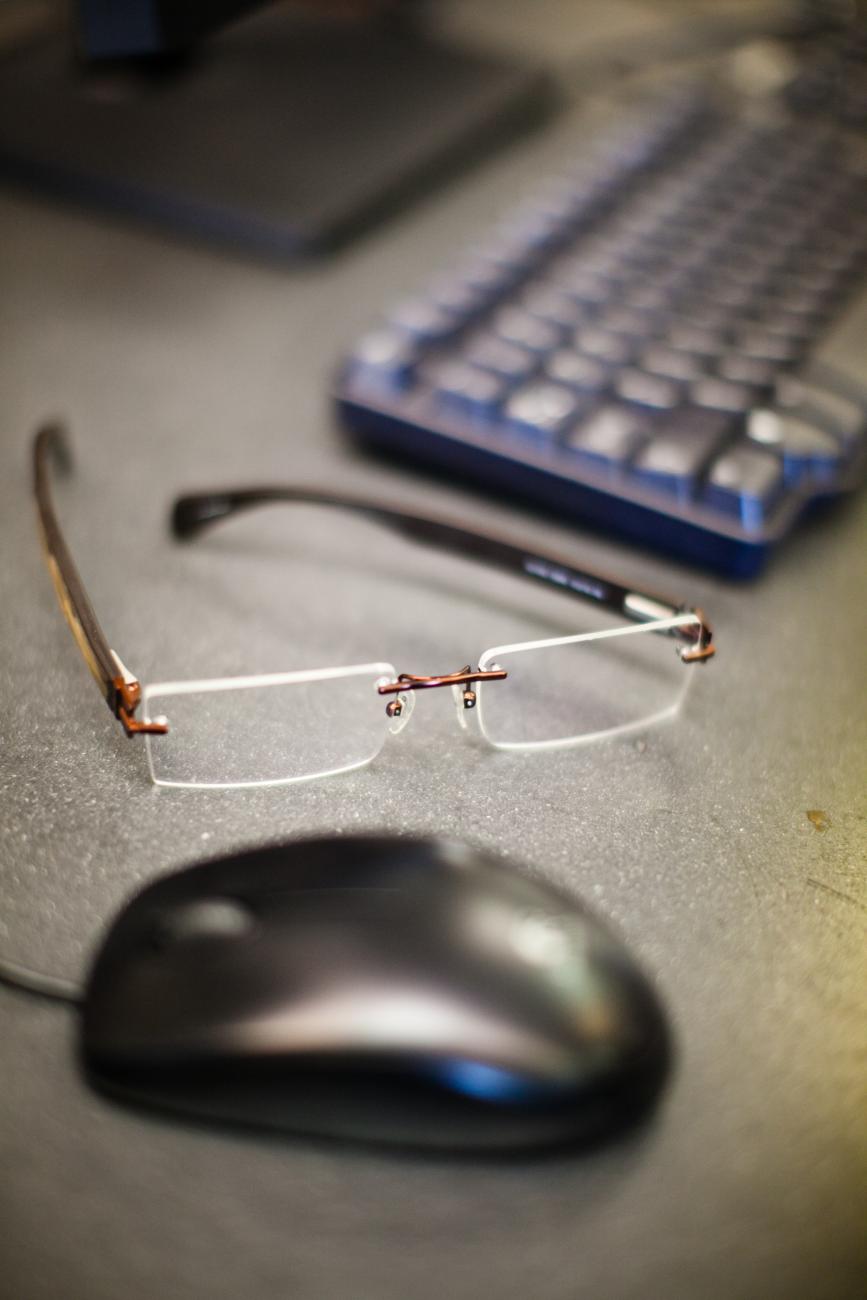 computer mouse and glasses on a desk