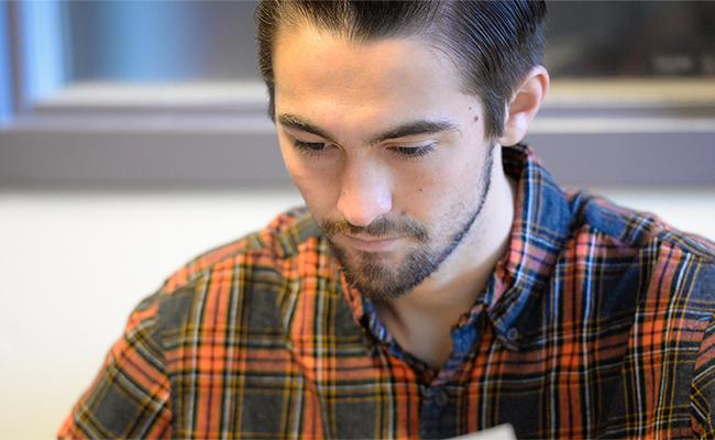 Communication student, Christian, reads the campus newspaper, The Yellow Jacket