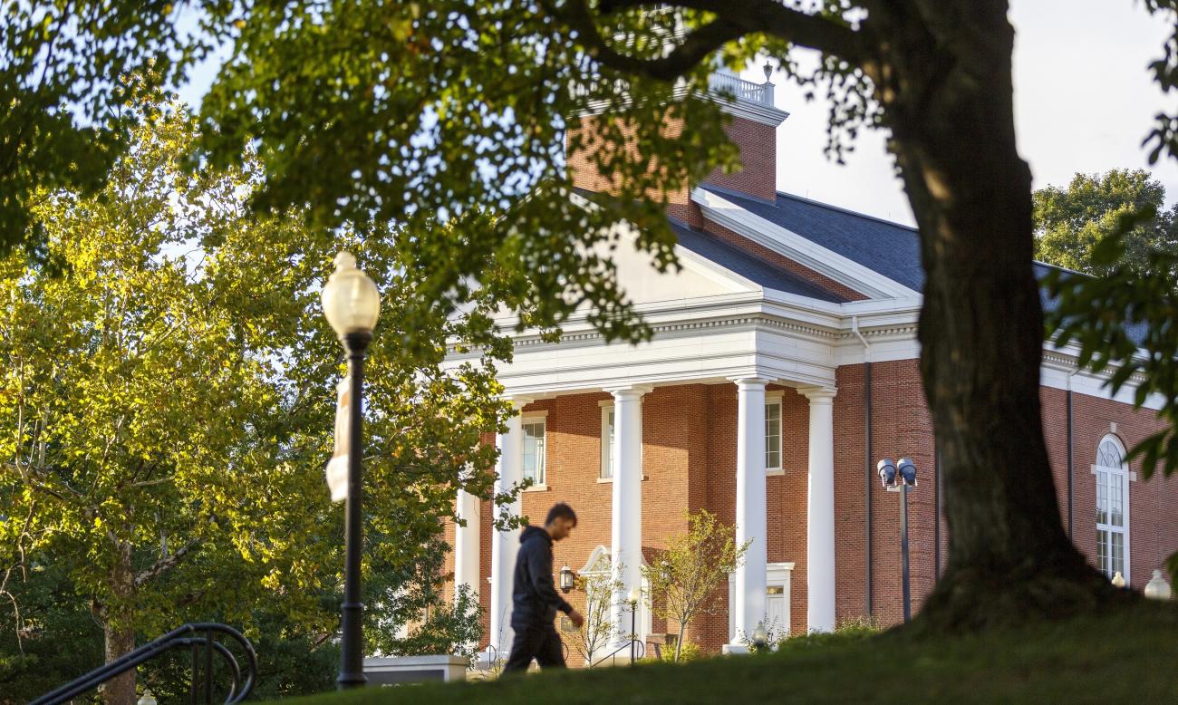student walks in front of waynesburg university's roberts chapel