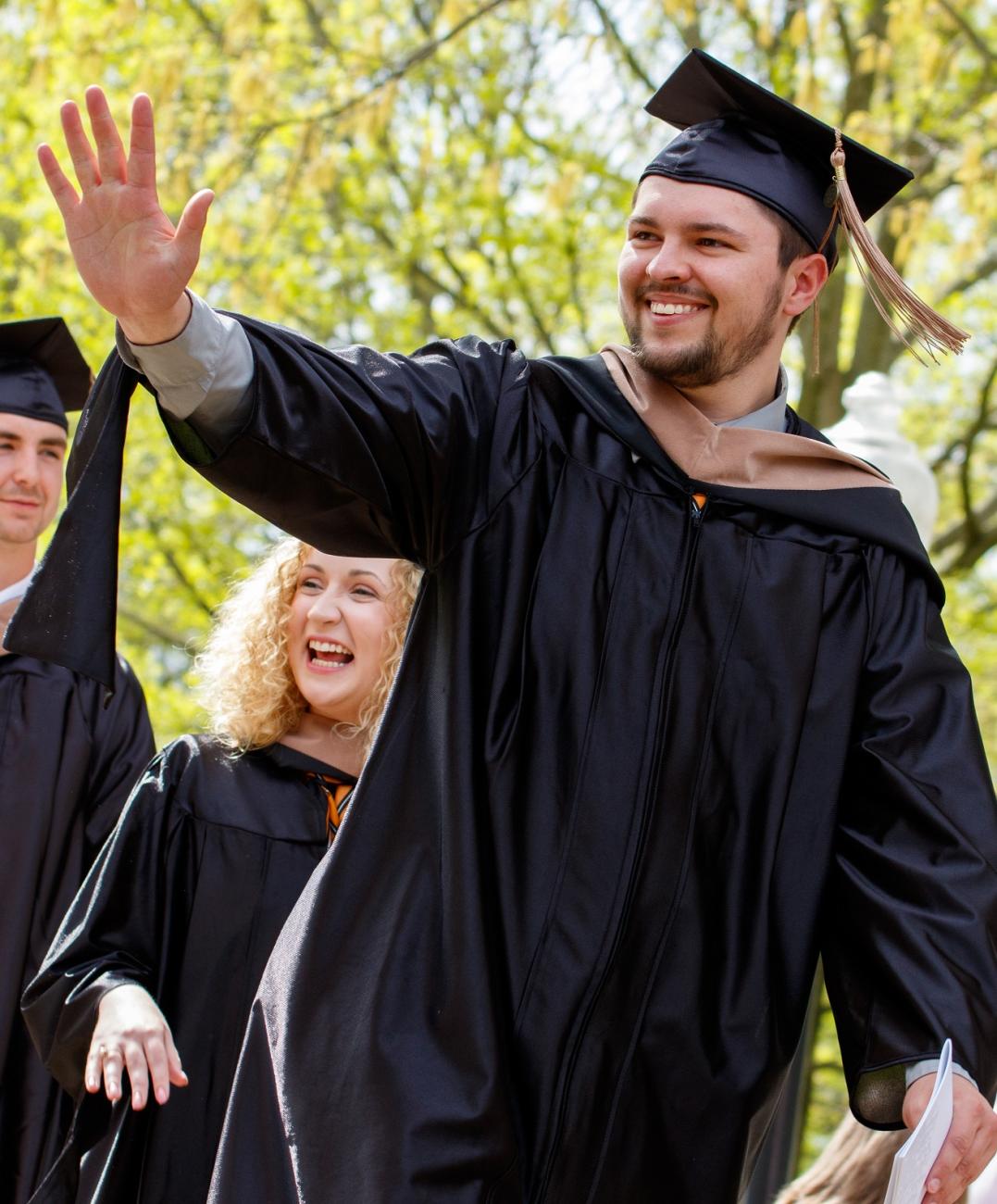 graduate student waving and smiling 