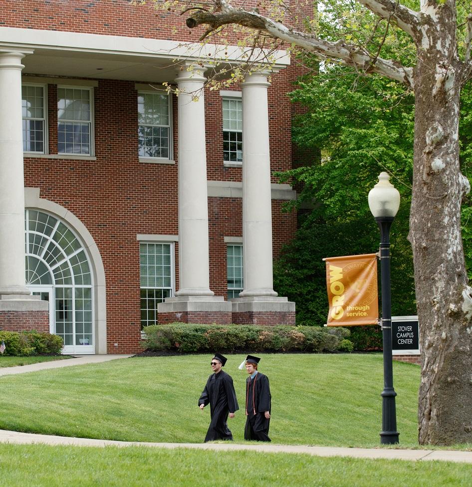 two students walking in regalia 