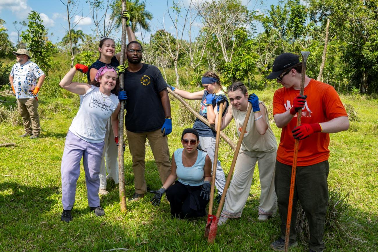 Group of students pose while building a new fence line for residents
