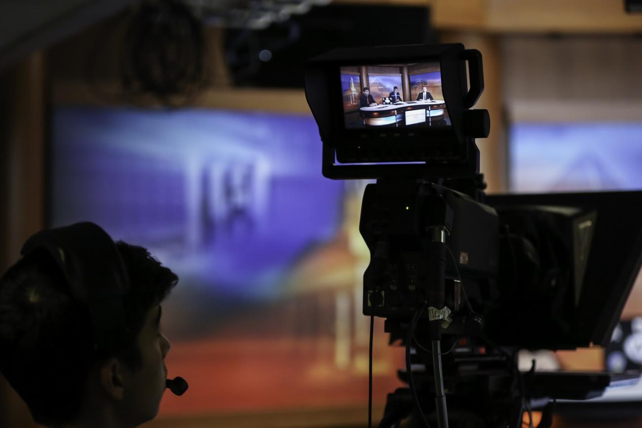 A student operates a video camera in the tv studio on campus.