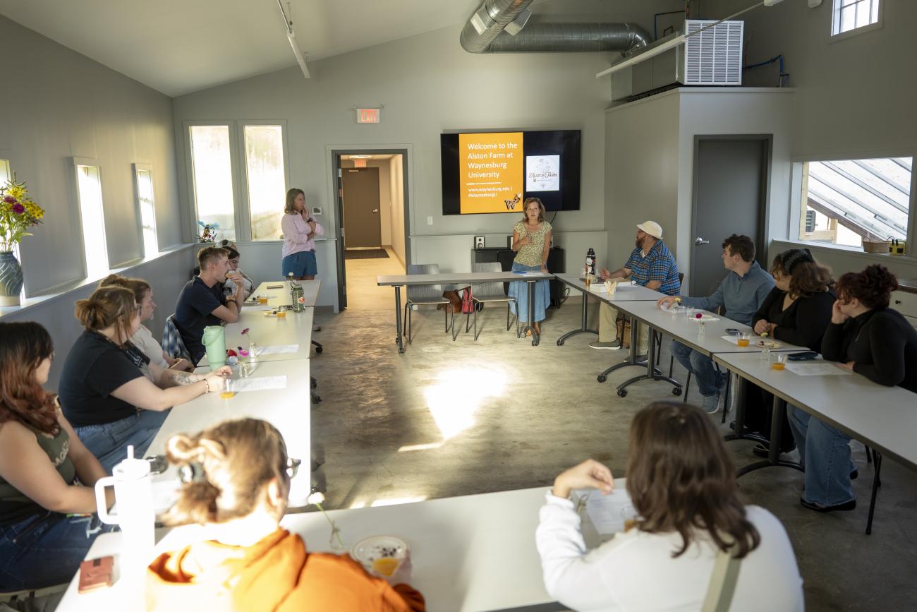 The classroom at the Alston farm property, with people seated around tables in a U-shape.