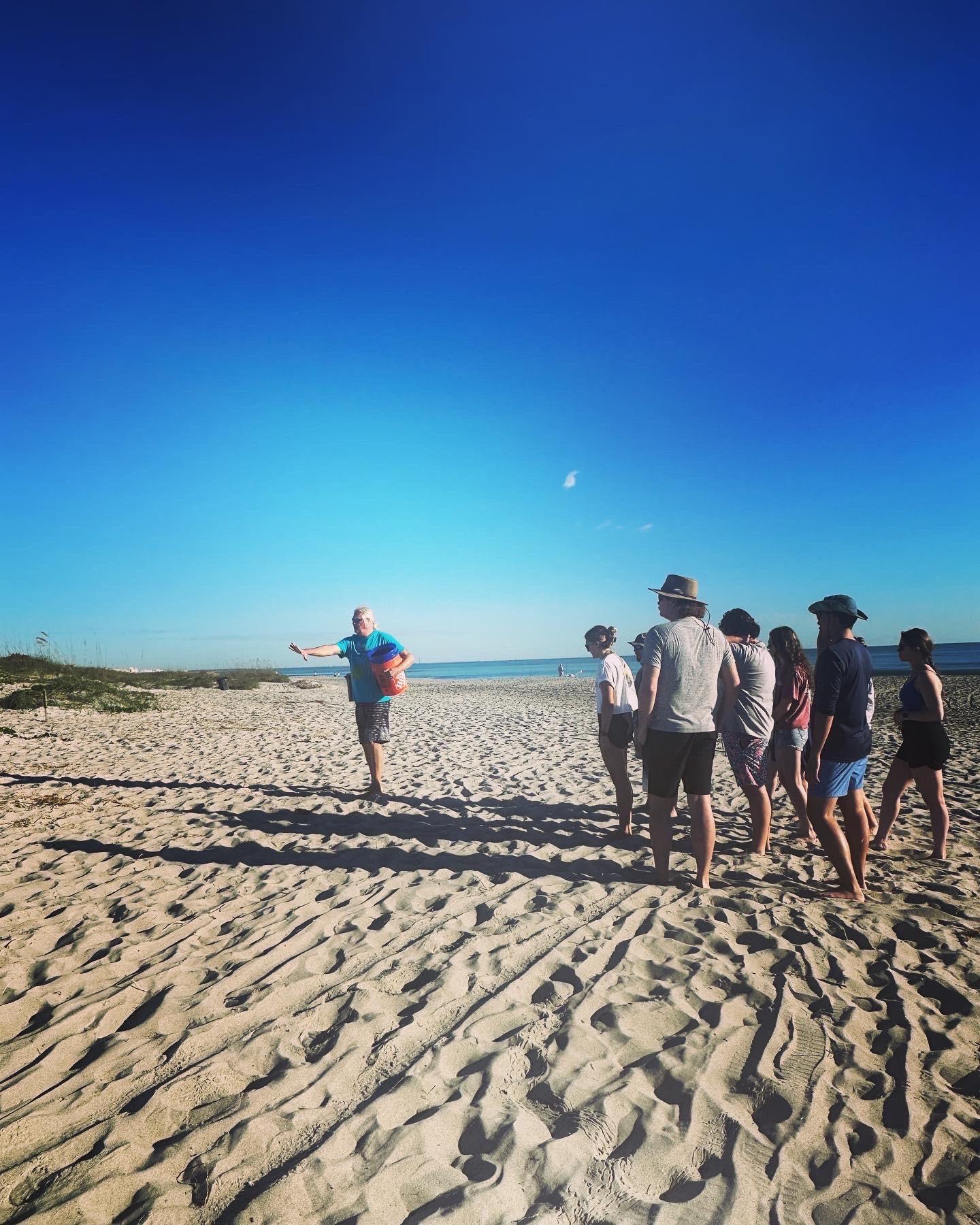 WU service trip group at A Rocha examines the beach