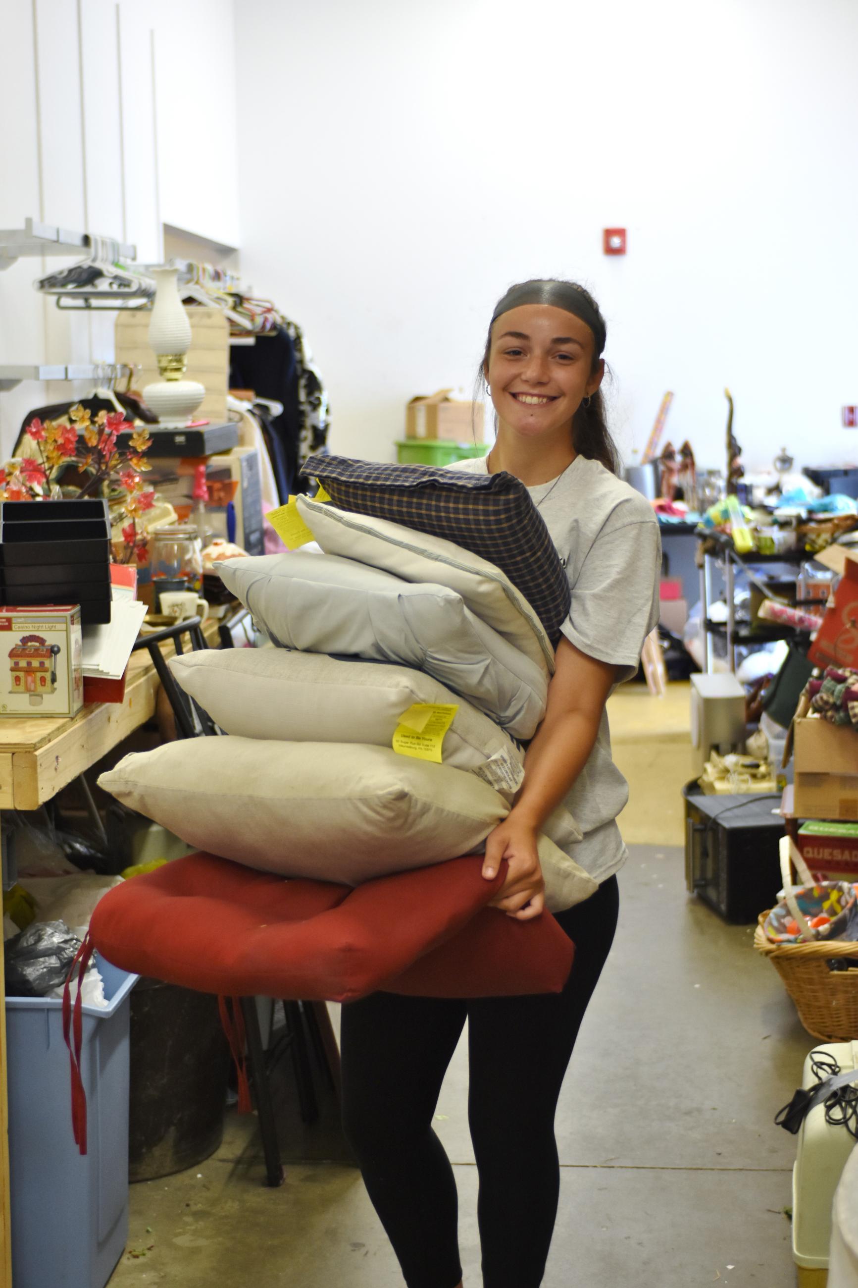 student carrying pillows during day of service