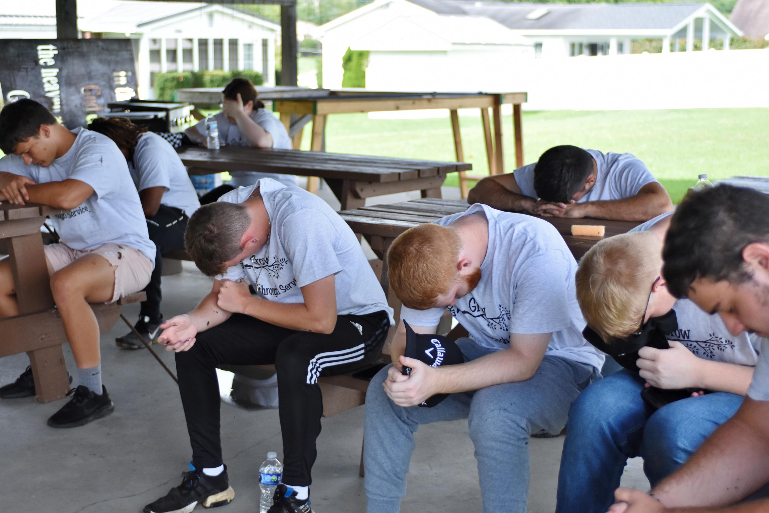 students praying during day of service