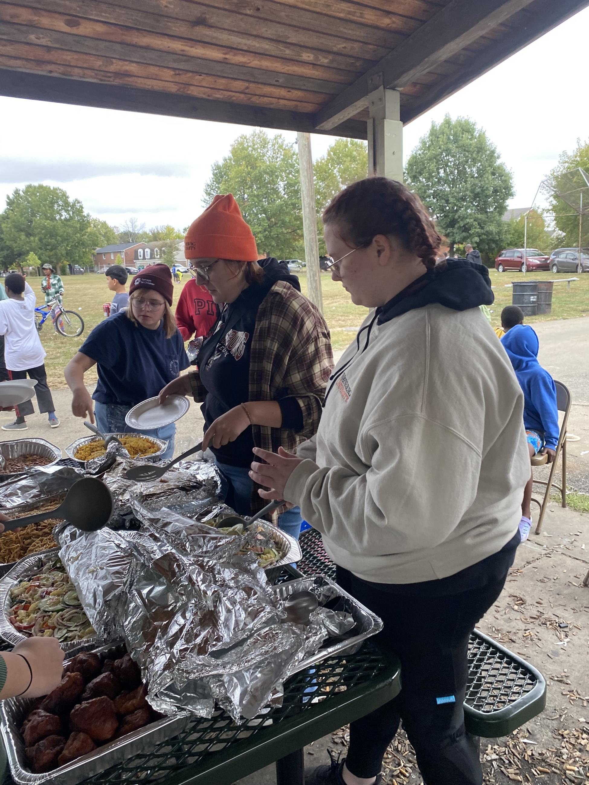 Students serve food at community cookout