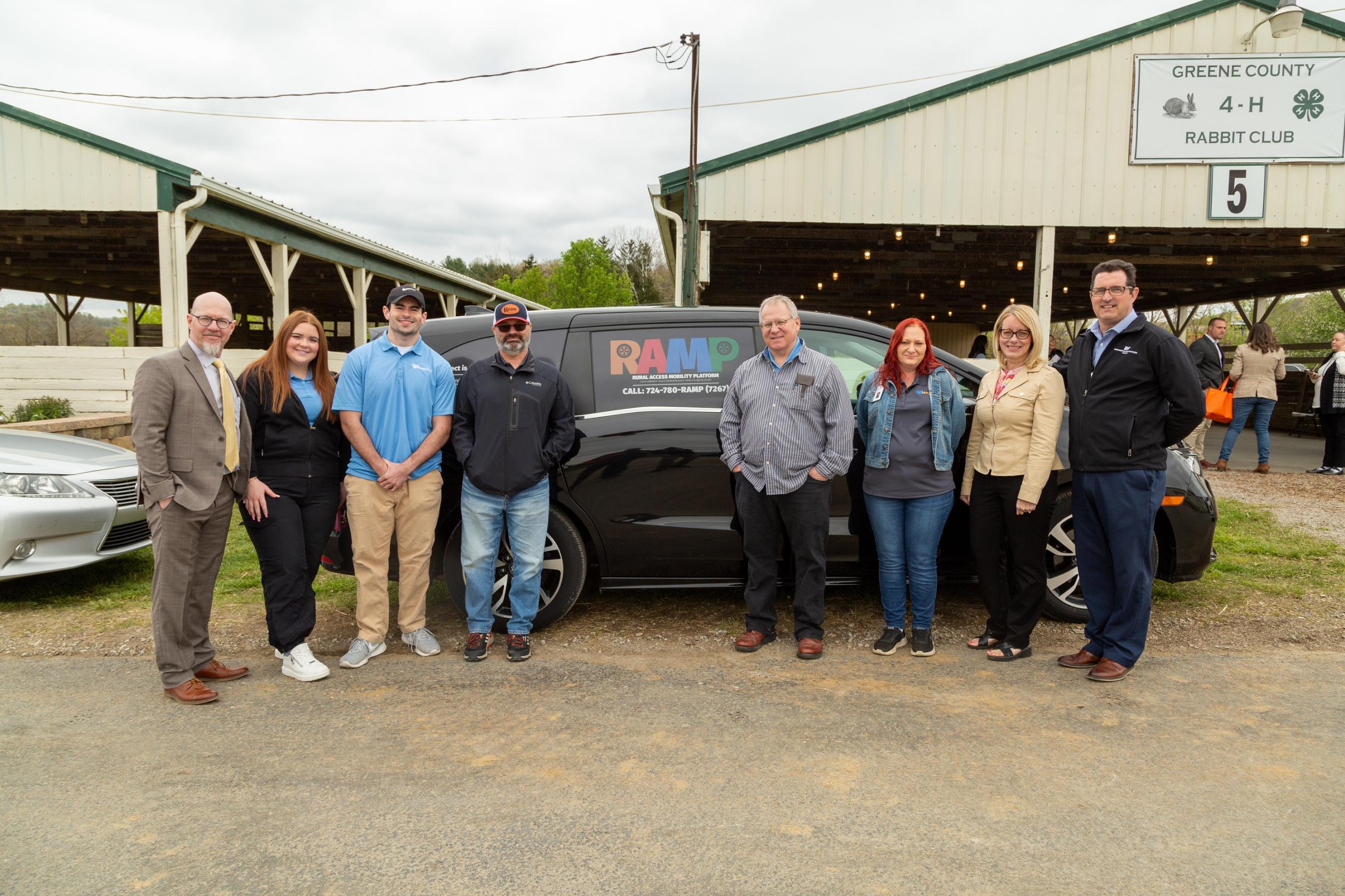 group of people standing next to van with RAMP Logo