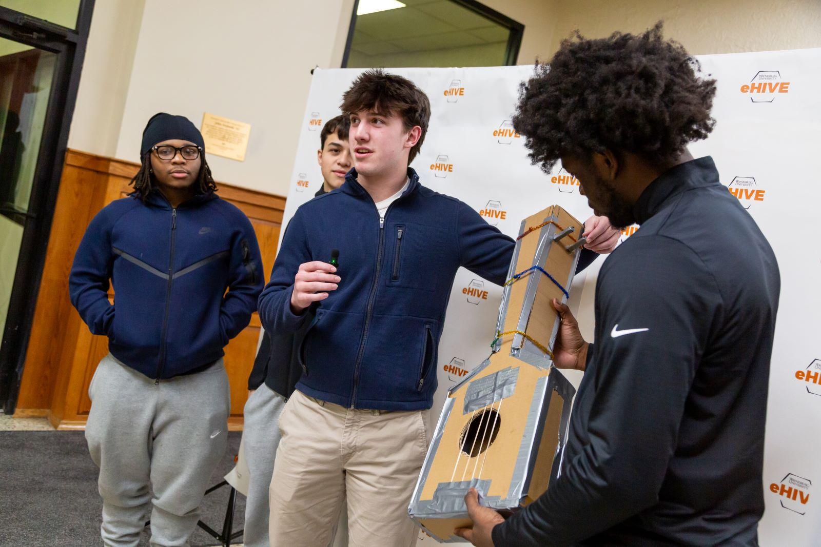 A group of boys display their innovative cardboard guitar