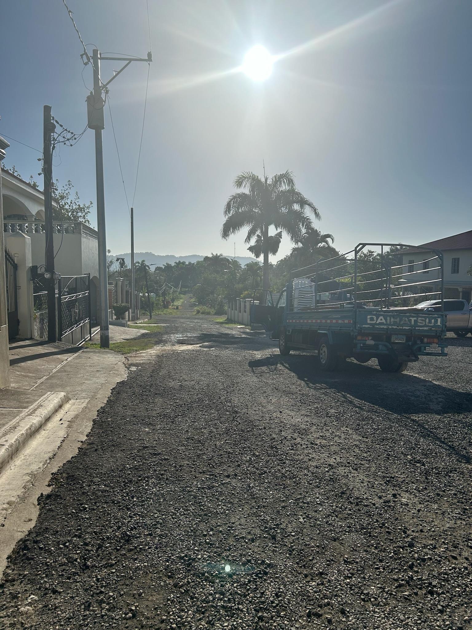 The sun shines down onto the driveway of Meeting God in Mission's and our group's blue cattle truck.