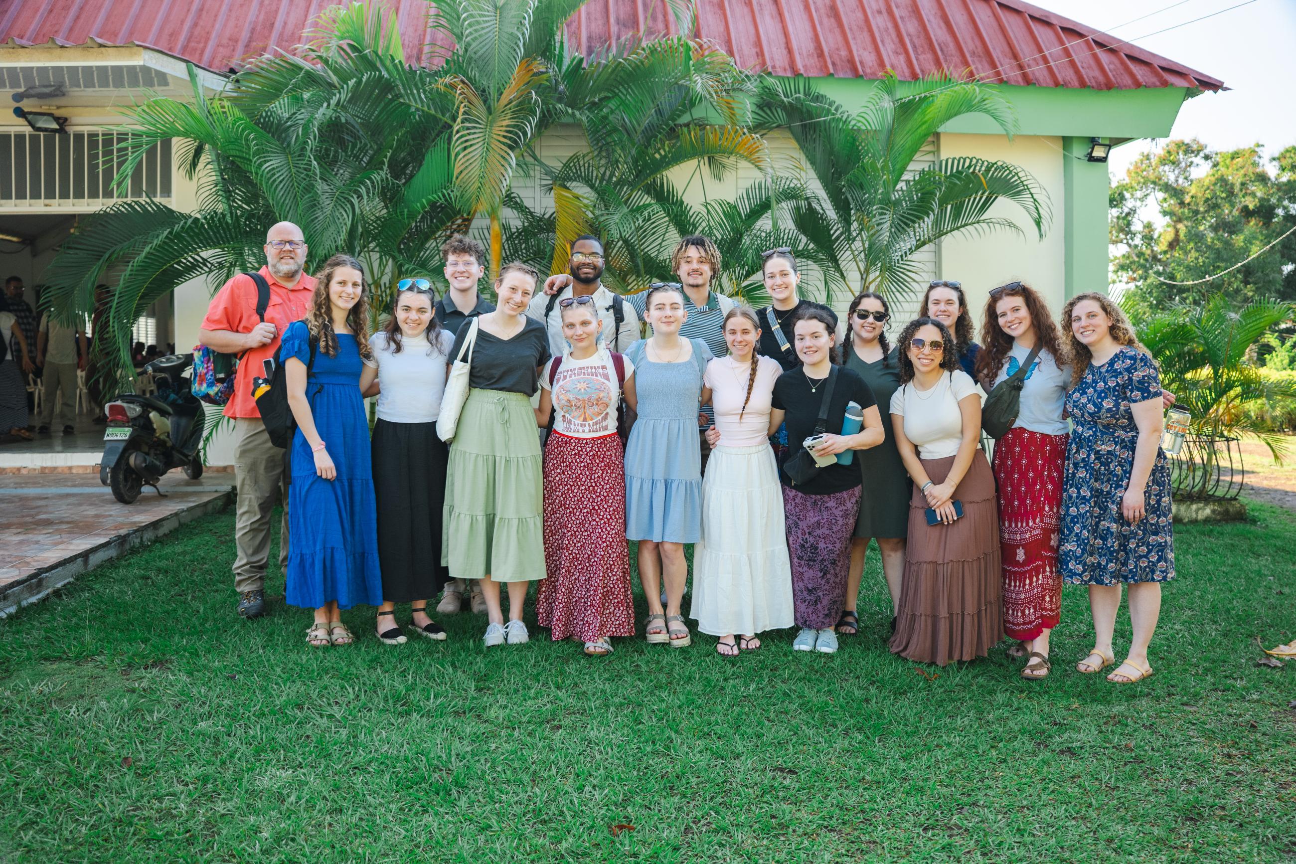 The Project GROW group stands in front of the Mountain Top Church. The church's roof is red while the walls are beige. 