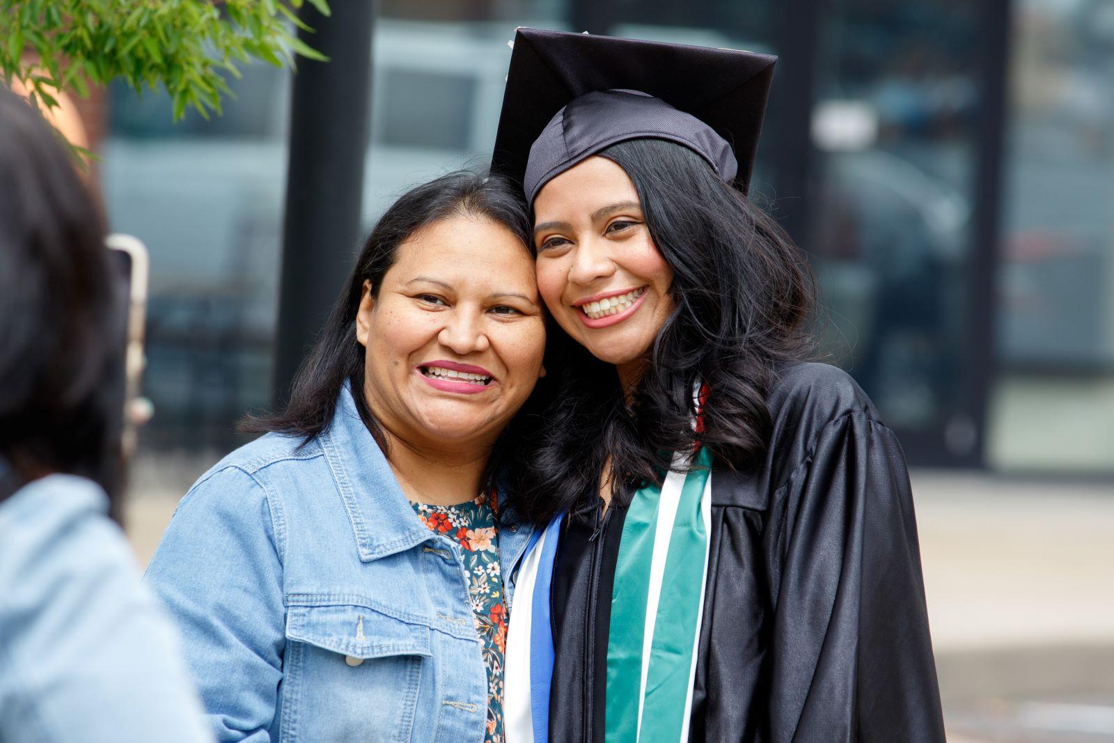 Graduate and parent pose for a picture