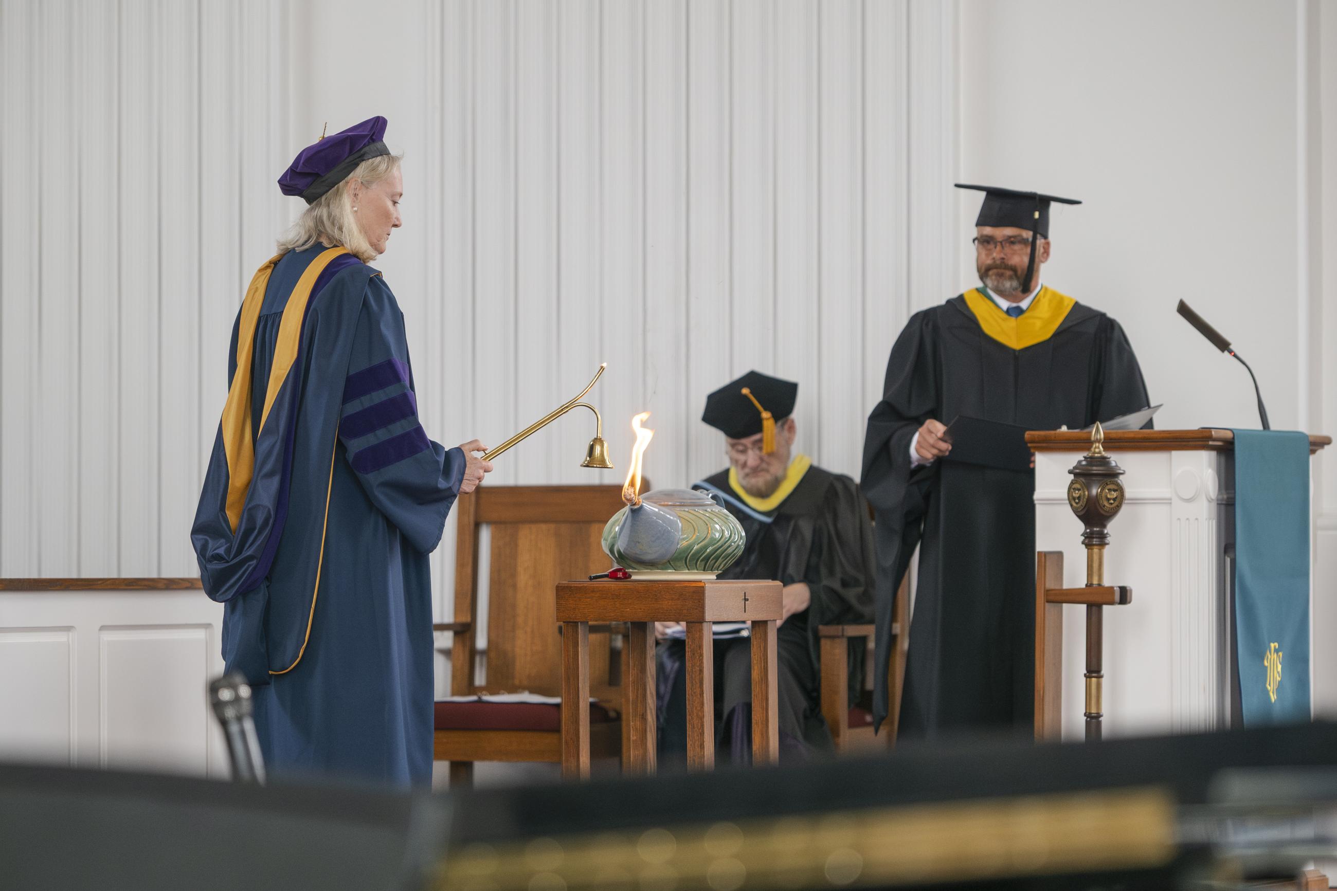 Provost Mindy Walls lighting her candle from the lamp
