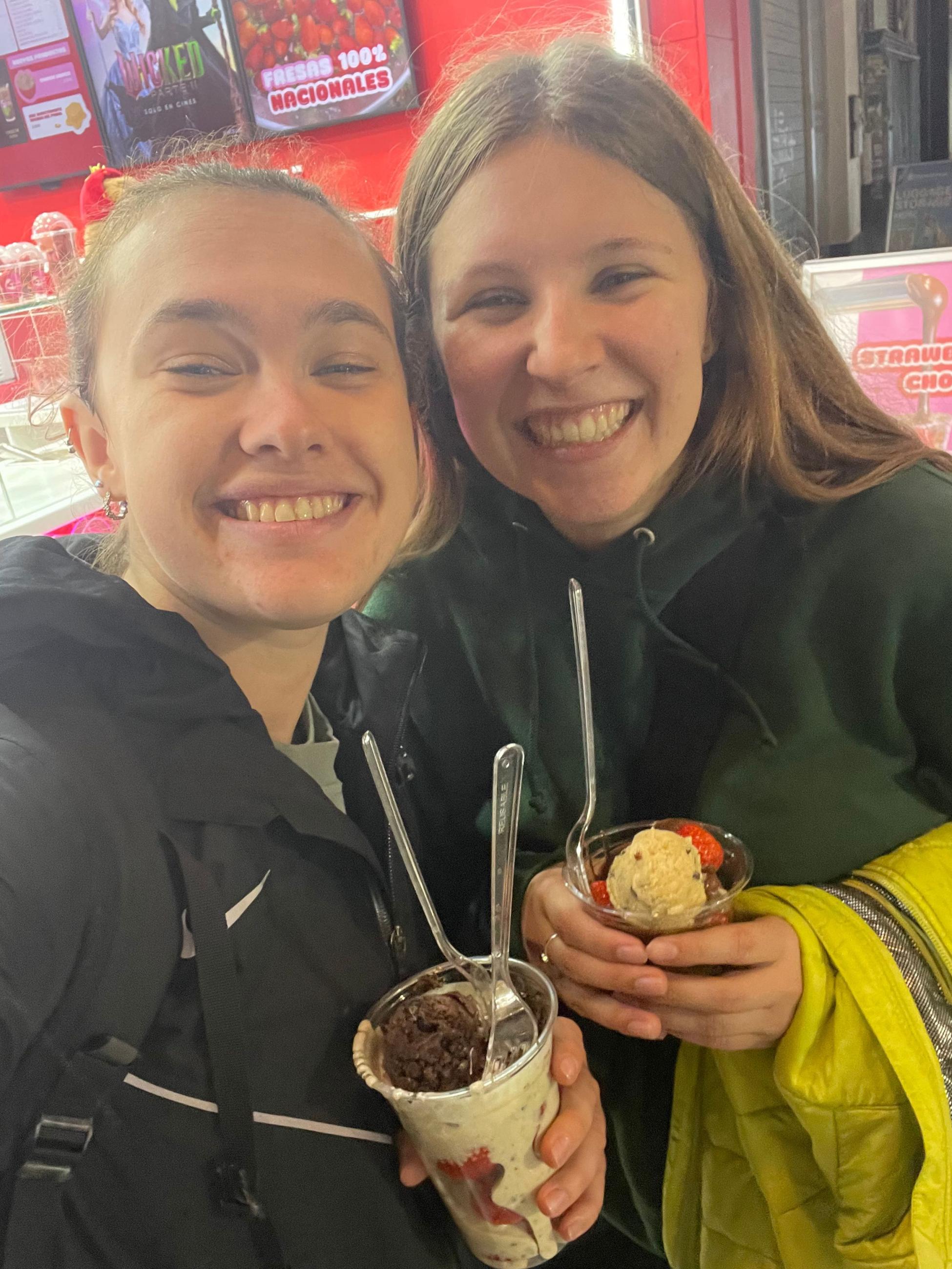 Natalie and a friend hold a dessert between the two of them. 