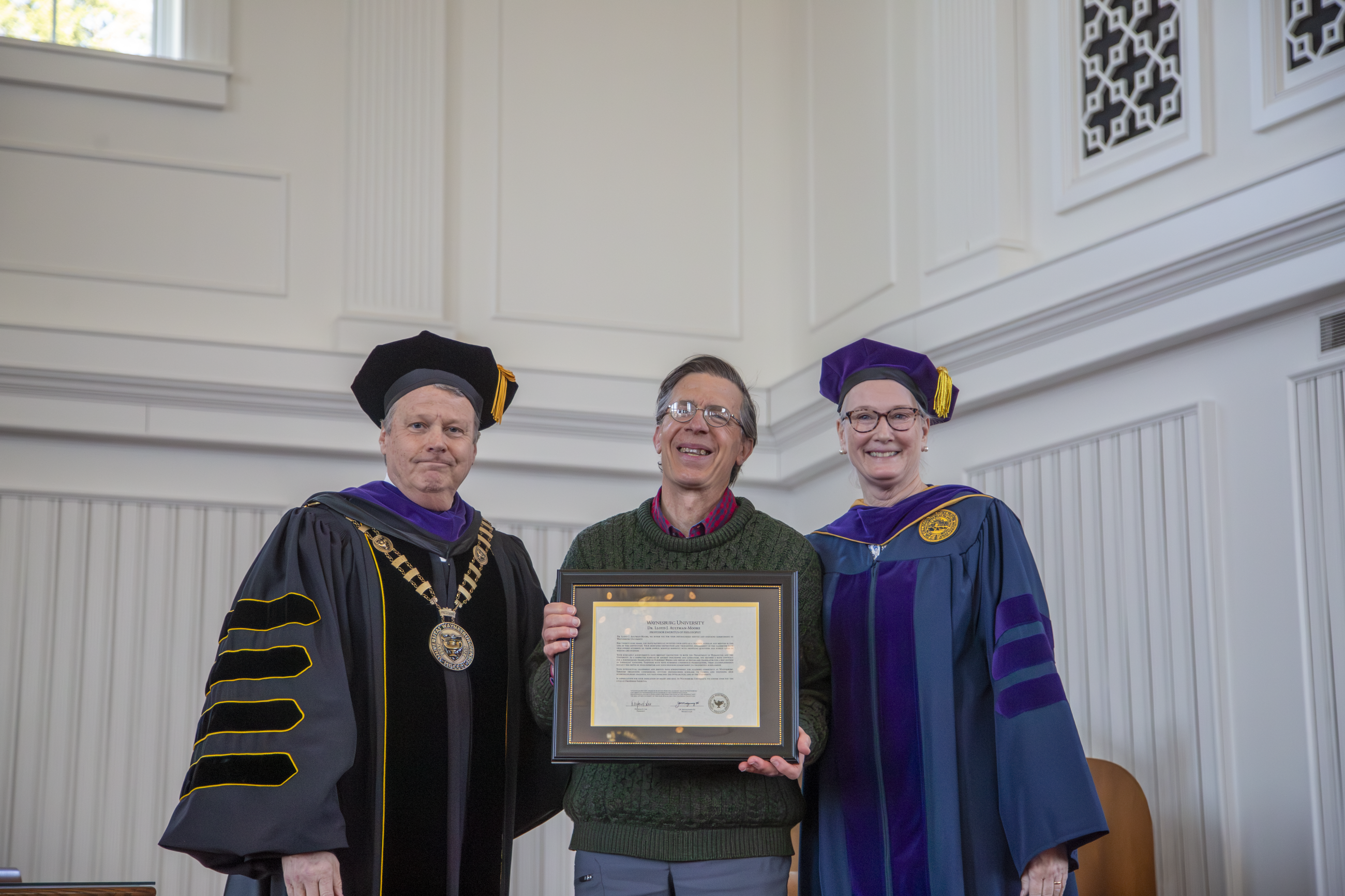 Dr. Lloyd Aultman-Moore (center) accepting his professor emeritus award from Provost Walls and President Lee