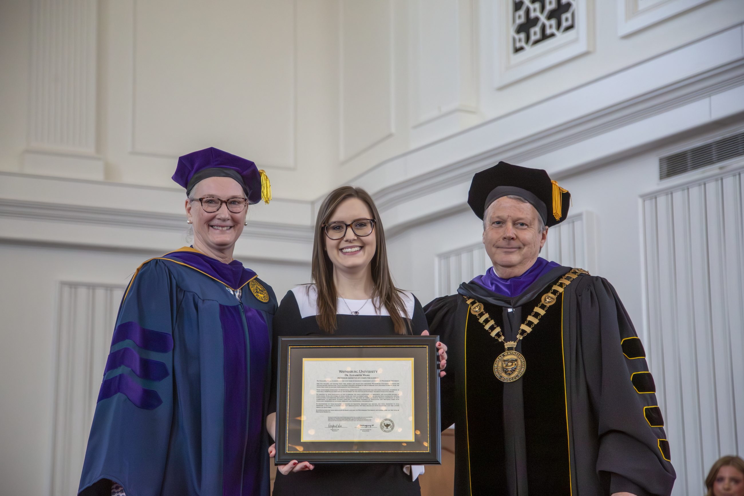 On behalf of Dr. Elizabeth Wang, Kylee Sargent (center) accepting professor emeritus award from Provost Walls and President Lee