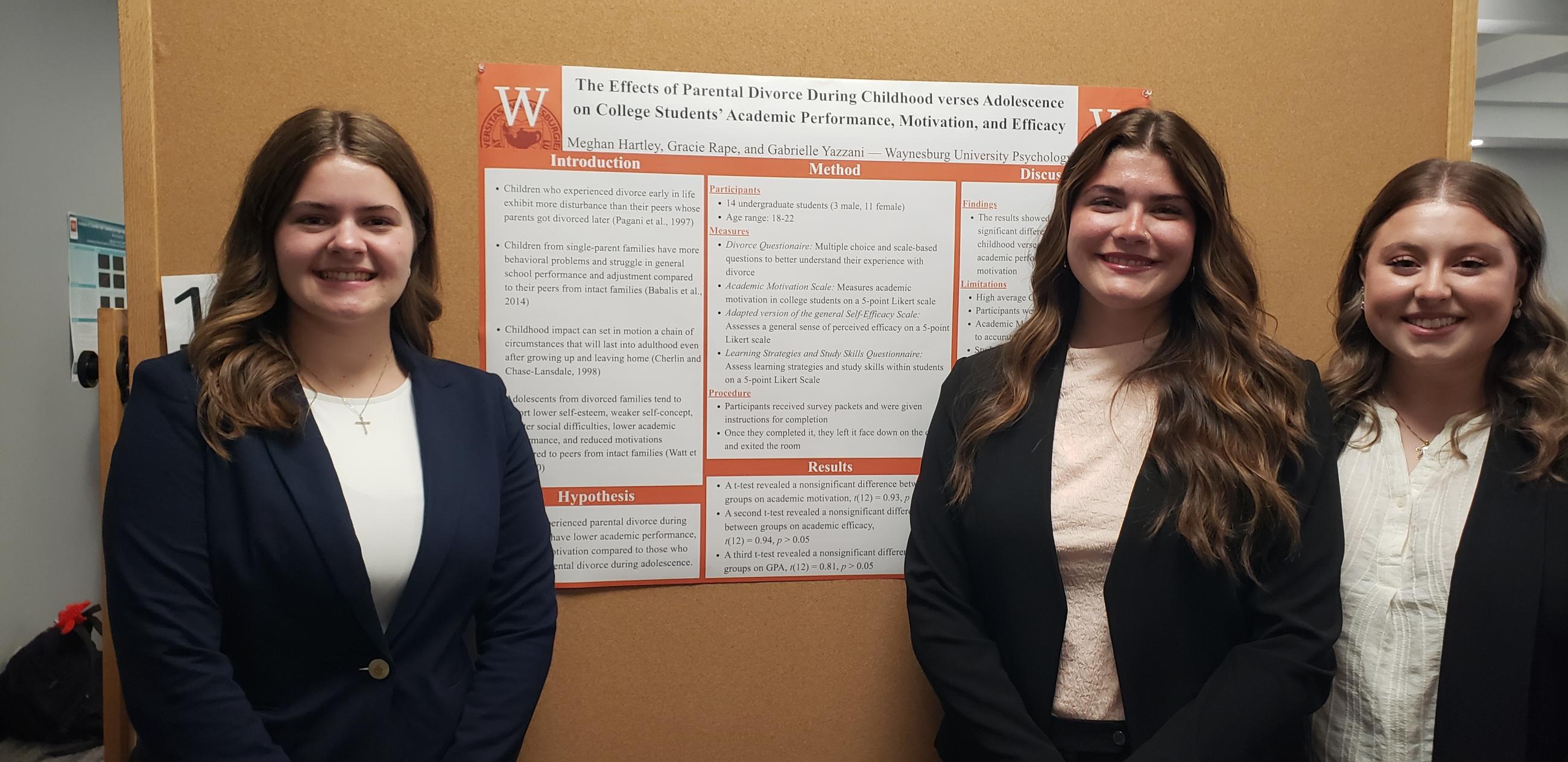 Three Waynesburg University students stand in front of their poster presentation at the Waynesburg University Research Symposium.