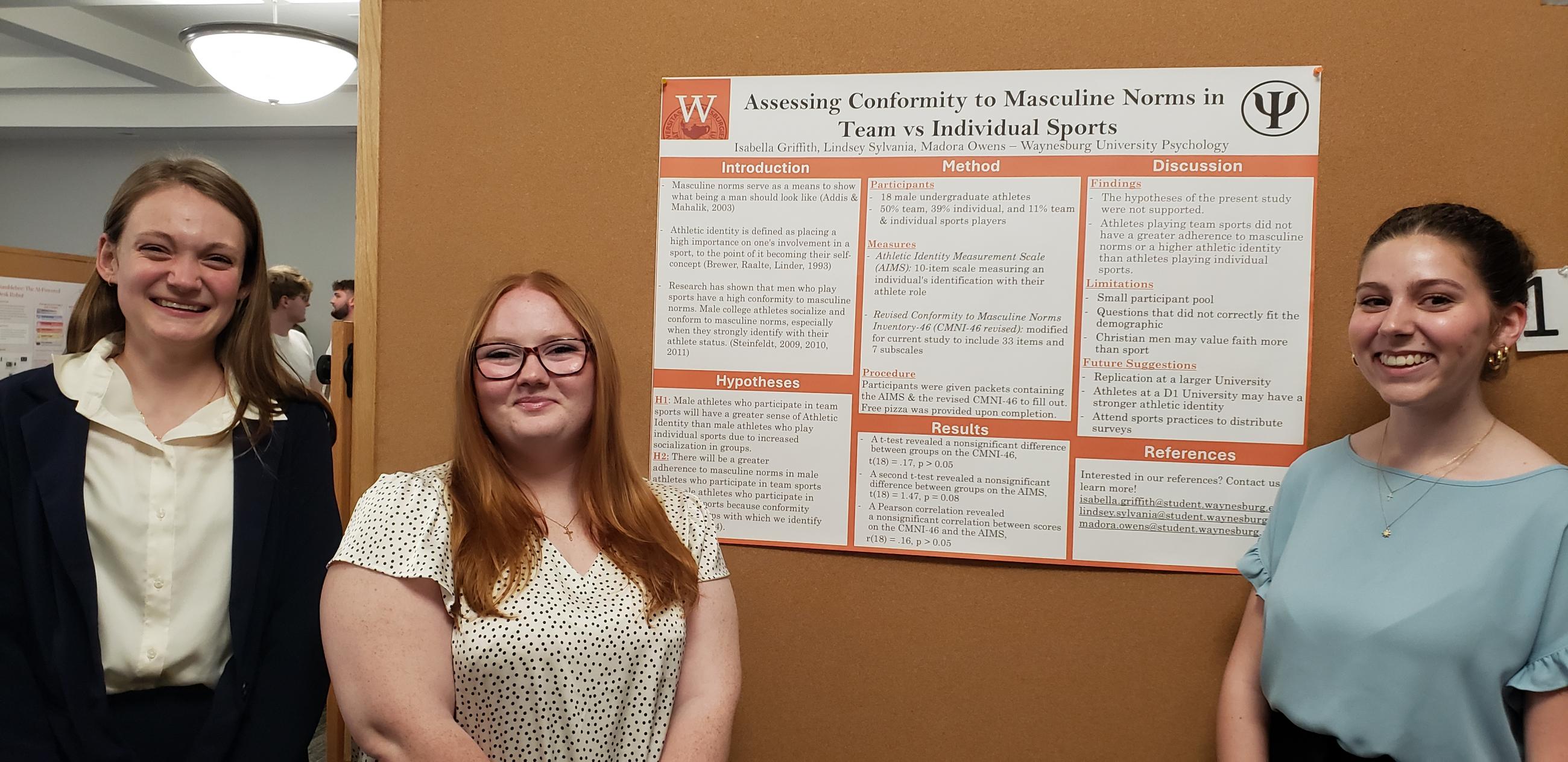 Three Waynesburg University students stand in front of their poster presentation at the Waynesburg University Research Symposium.