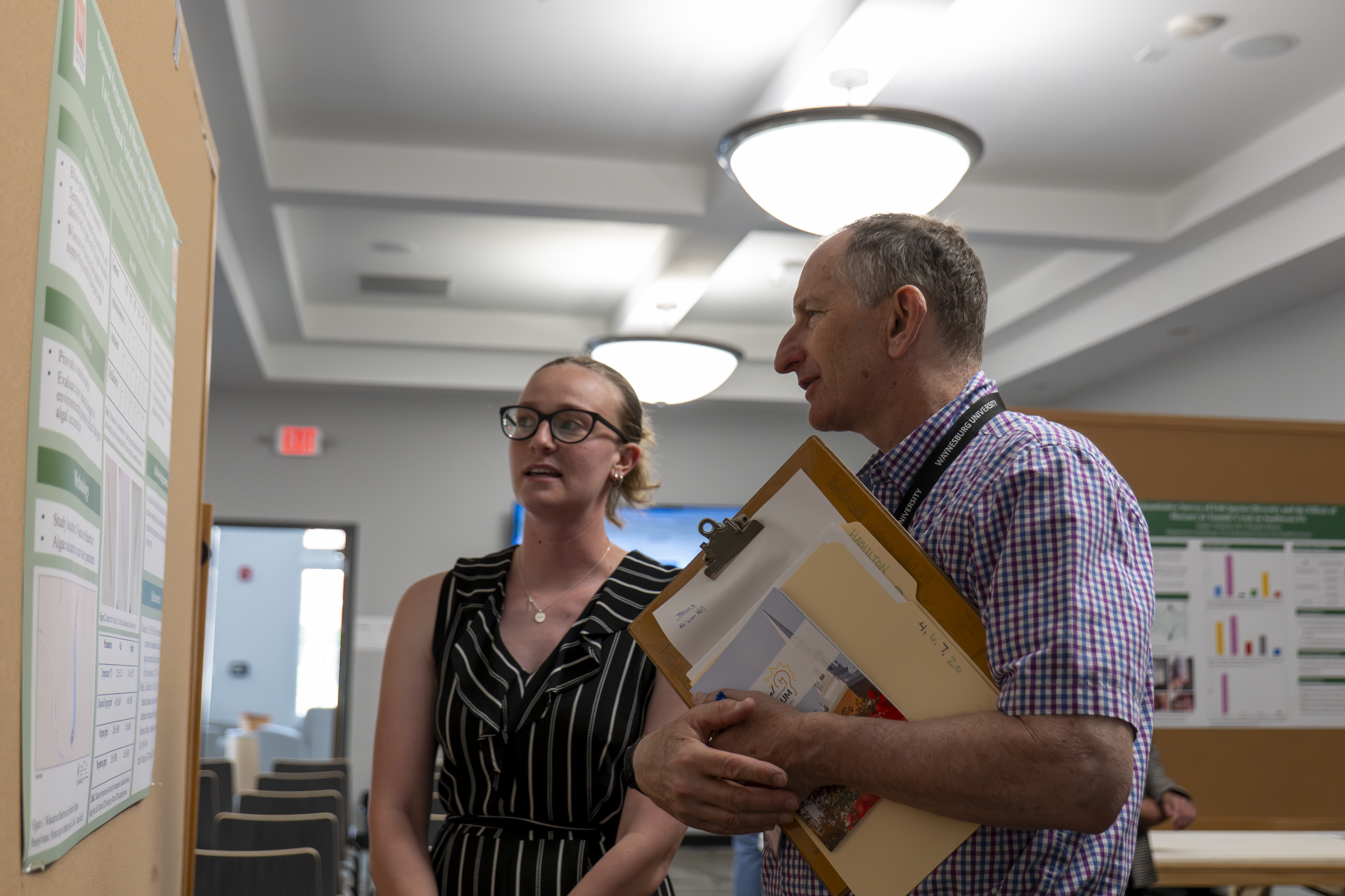 Student presenting research poster to Professor Bryan Hamilton