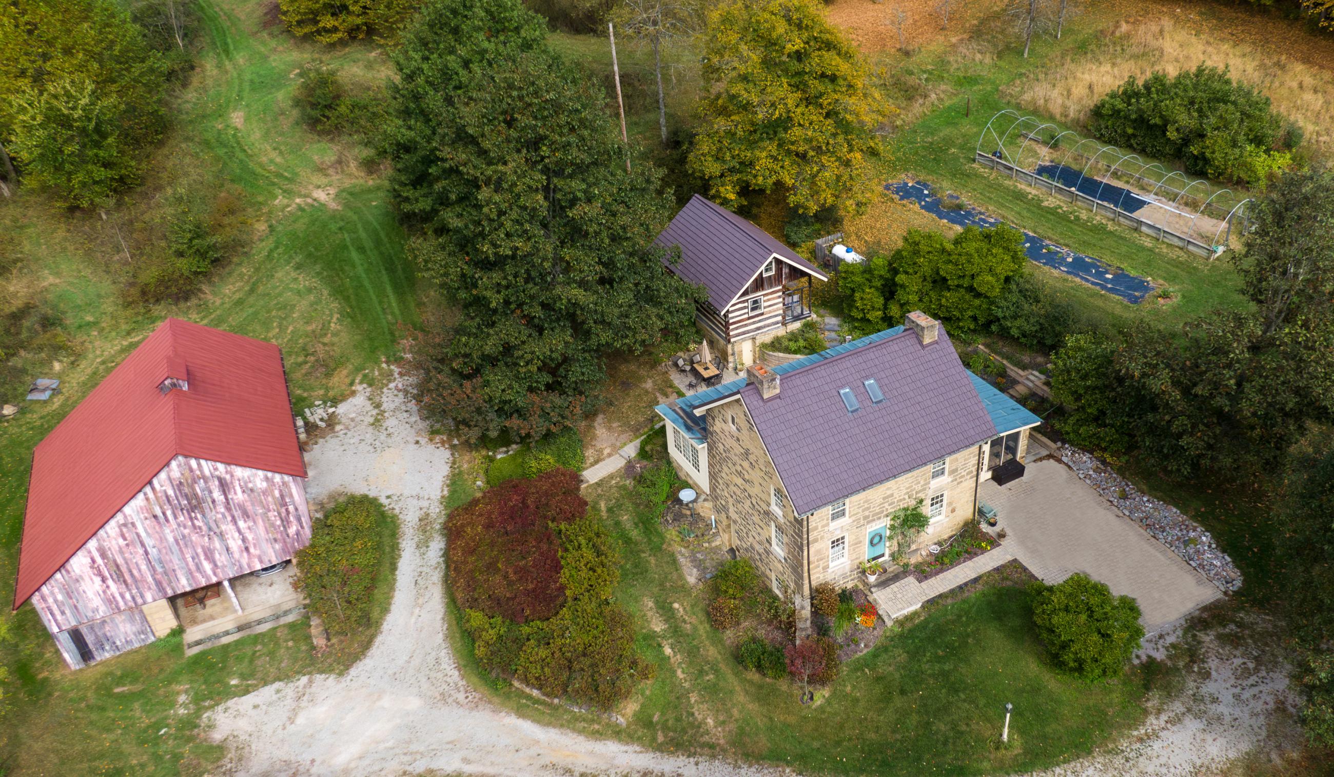 Birdseye view of the historic farmstead, including the stone house, log building and a barn. 