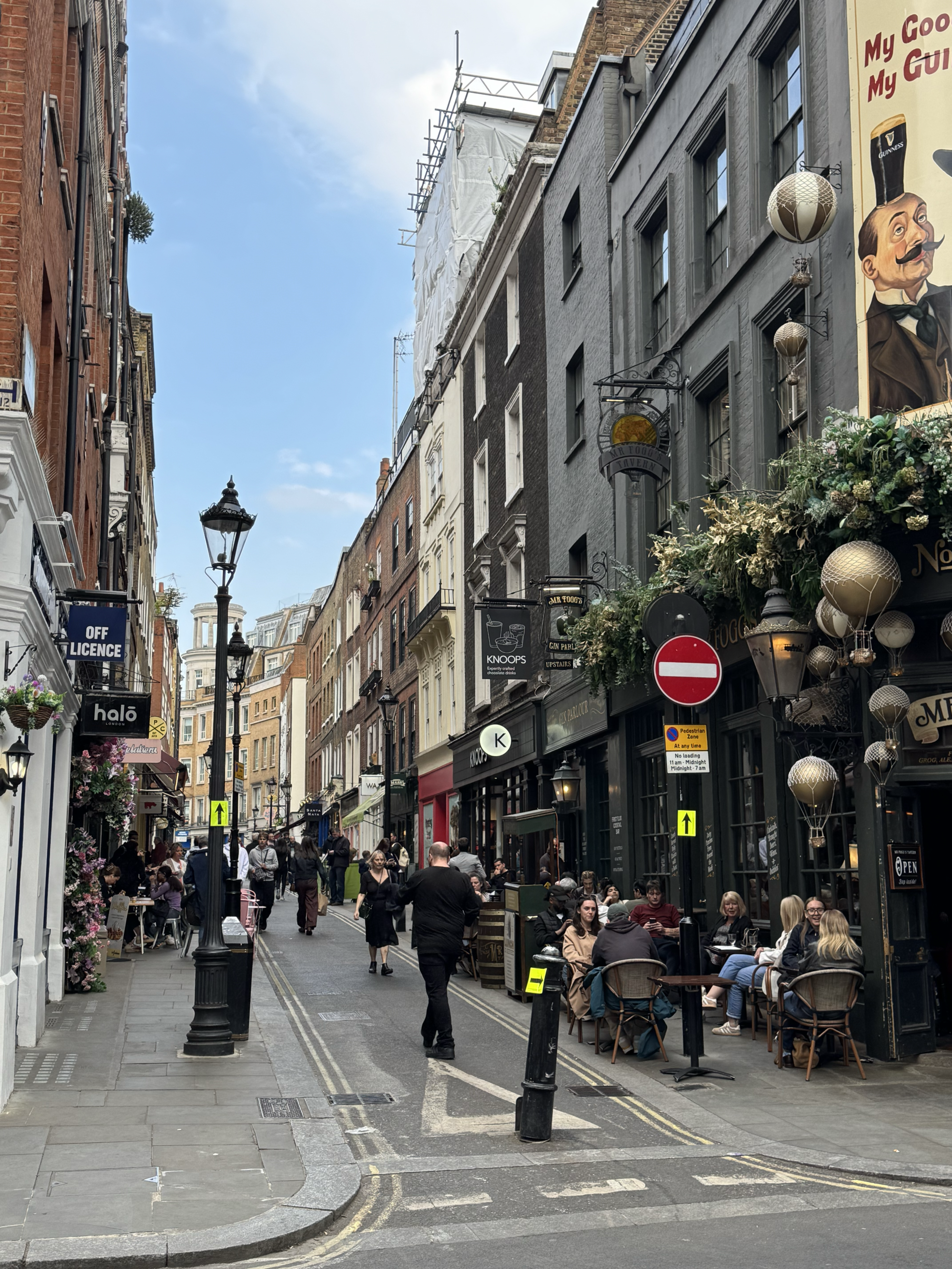 A busy street with stone storefronts and pubs
