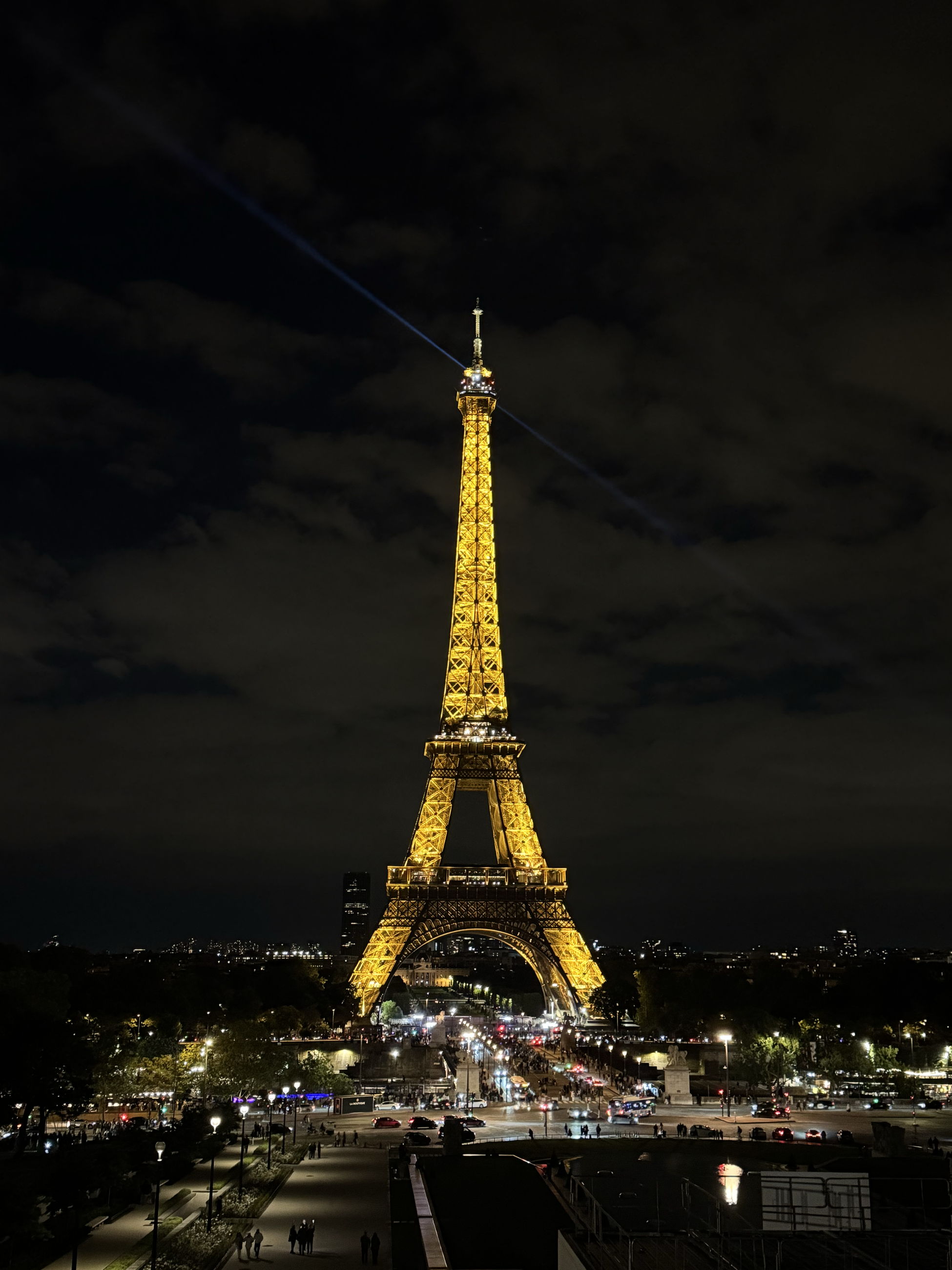 The Eiffel Tower, a tall metal industrial structure, is illuminated and sparkles at night. 