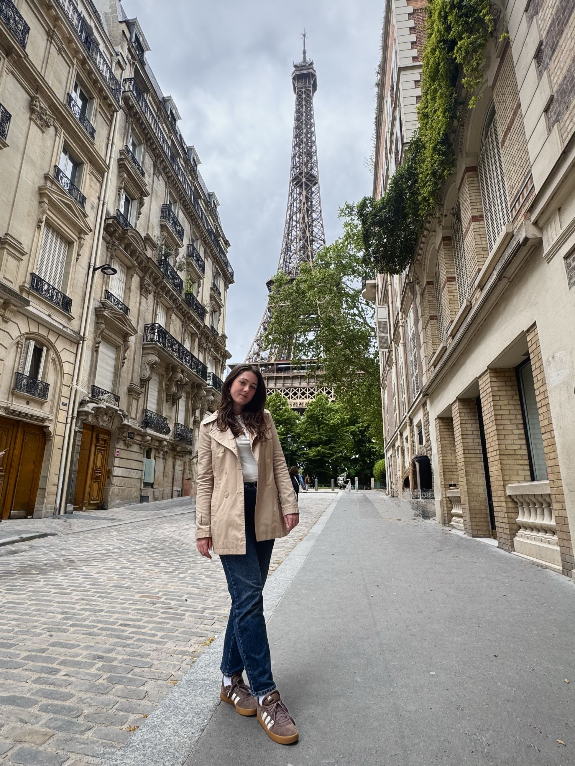 Meredith poses in front of the Eiffel Tower, a tall metal industrial-style structure