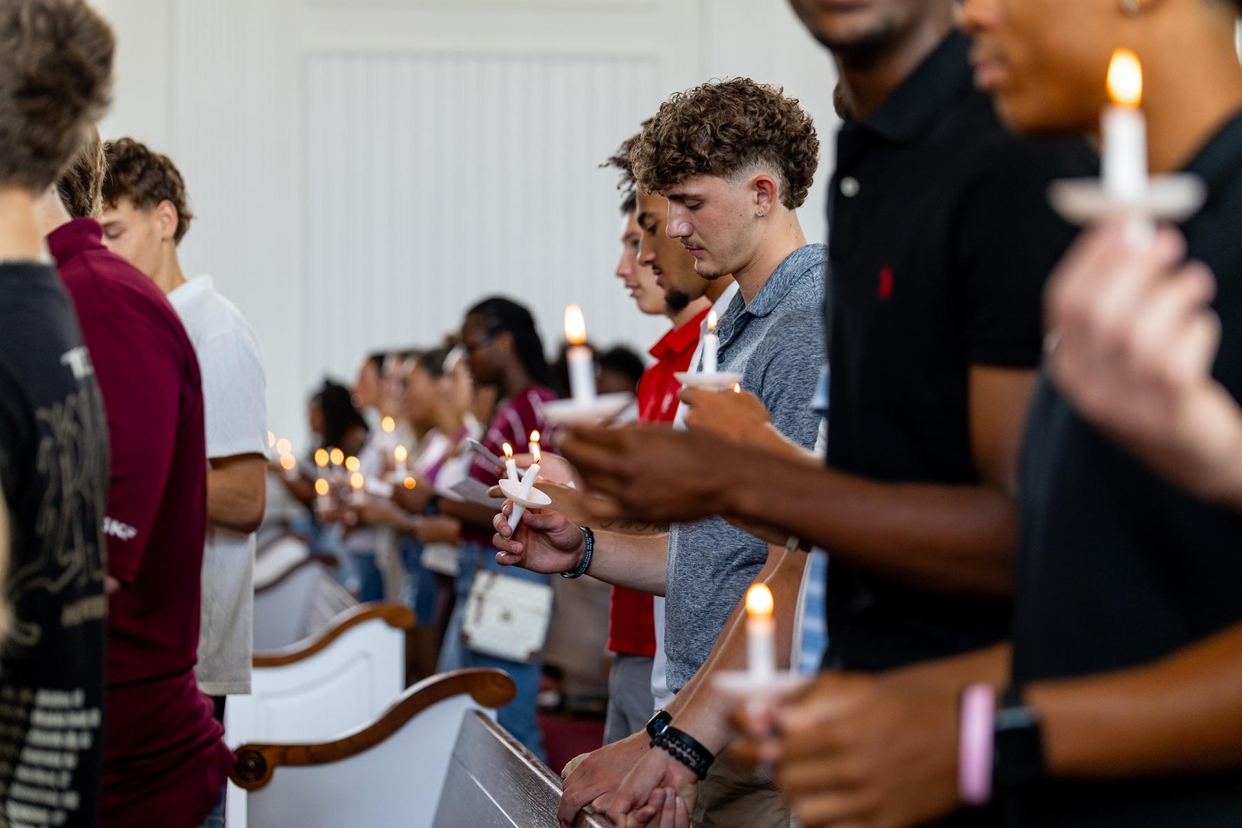 Students hold candles during the matriculation ceremony.