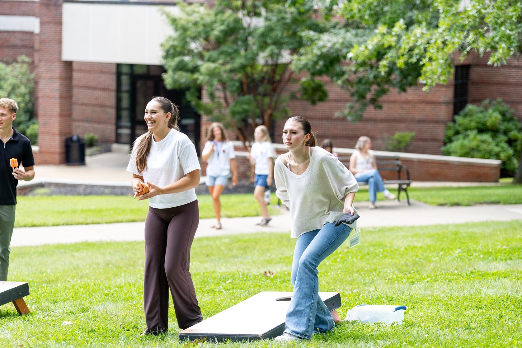 Students play cornhole. 