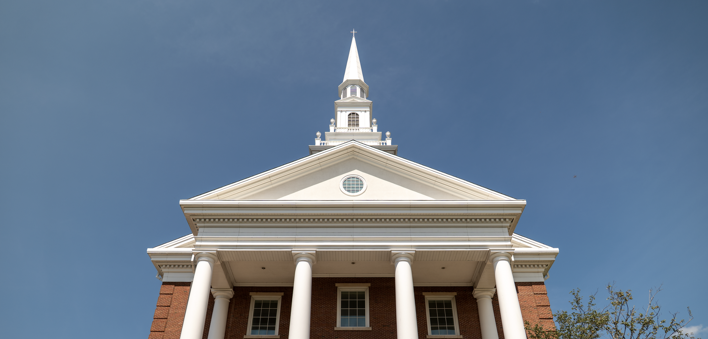 The top of Roberts Chapel, including the steeple, against a clear blue sky