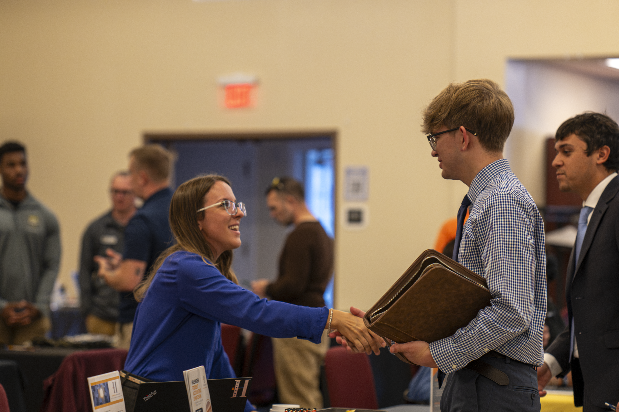 A student shaking hands with an employer at the Business & Communication Job & Internship Fair held in the Marsh Center on campus
