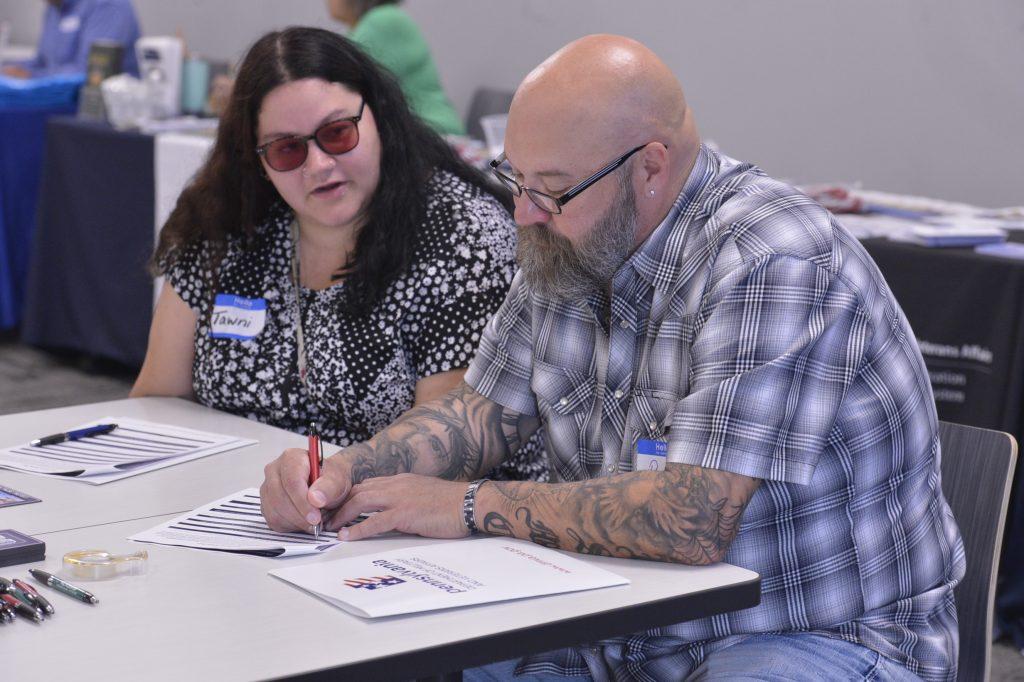 Tawni Feeney, a Waynesburg University counseling graduate student from Belle Vernon, and Patrick Meighen of Washington, a volunteer with Together with Veterans, work on gun owner safety plans (photo credit: Garrett Neese, Observer-Reporter)