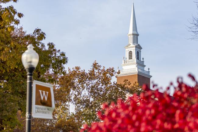 A bright red tree sits below Roberts Chapel in the distance.