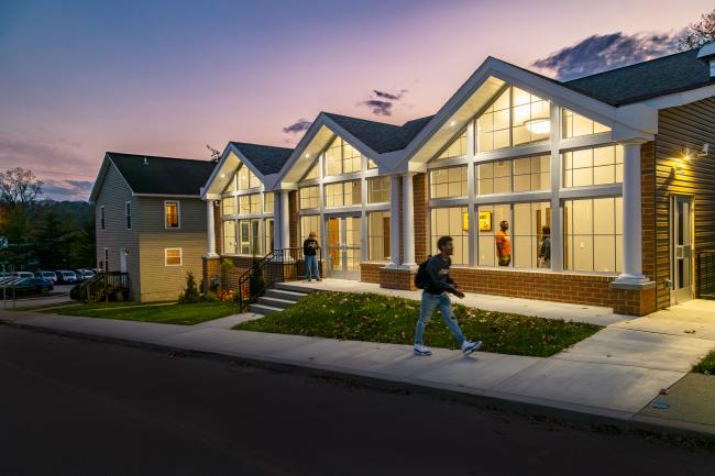 The Center for Criminal Justice & Forensic Investigation pictured at dusk with a person walking on the sidewalk in front of it.