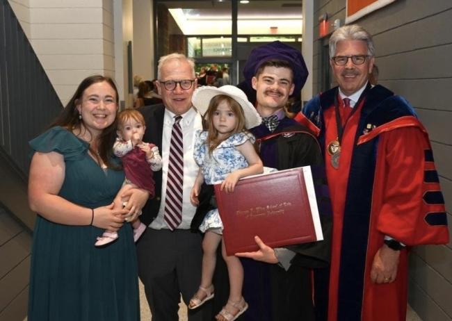 Daniel pictured with his family and Dr. Larry Stratton as well as a faculty member at his law school graduation