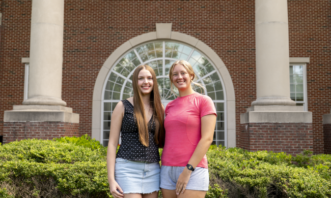Addison and Madison stand together in front of Stover Campus Center. 