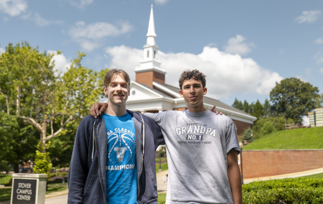 Spencer and Lukas standing together with the Chapel in the background.