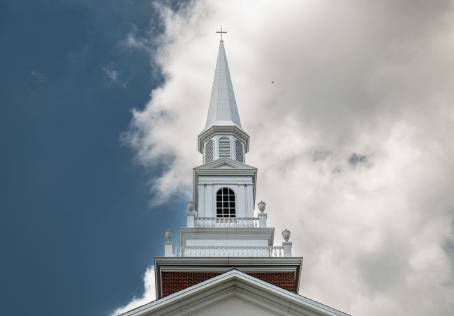 Roberts Chapel steeple against a blue sky with white clouds